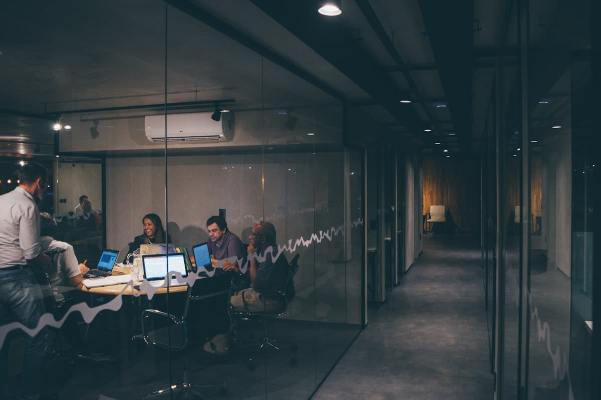 A late working session in a glass-walled meeting room